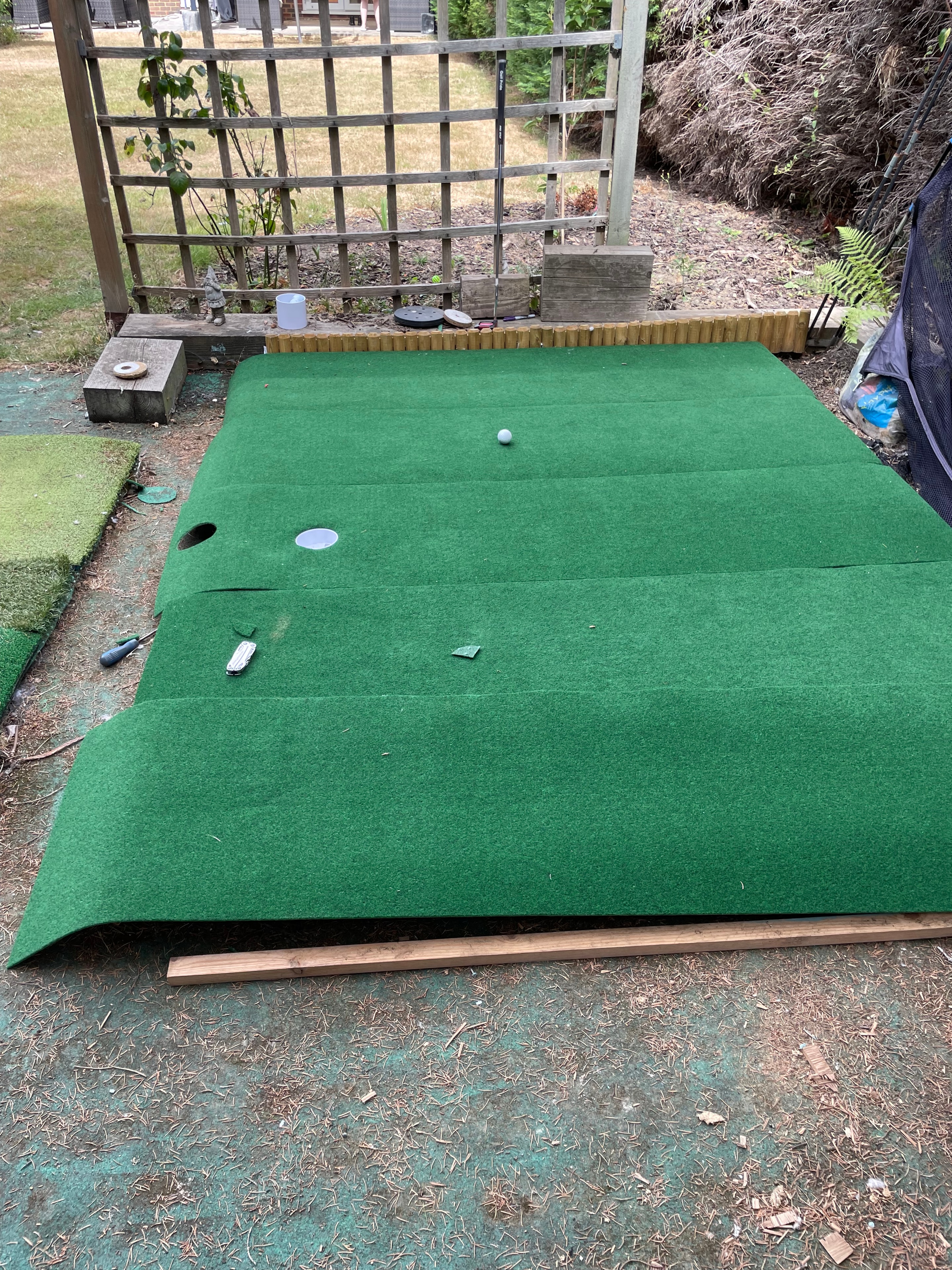 Overhead view of a finished garden putting green with two hole positions